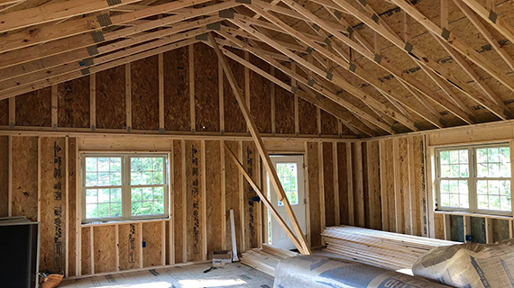 stripped down room interior with exposed roof trusses and wall supports