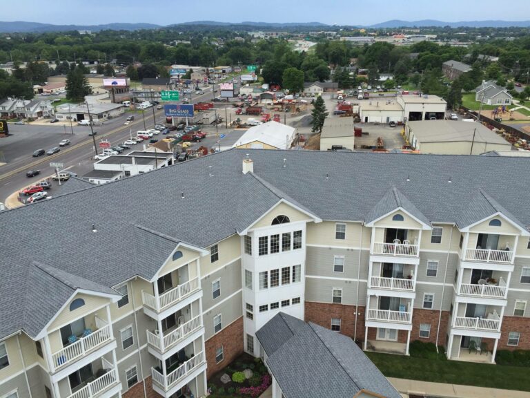 White residential apartment building with a grey shingle roof in Avon, PA